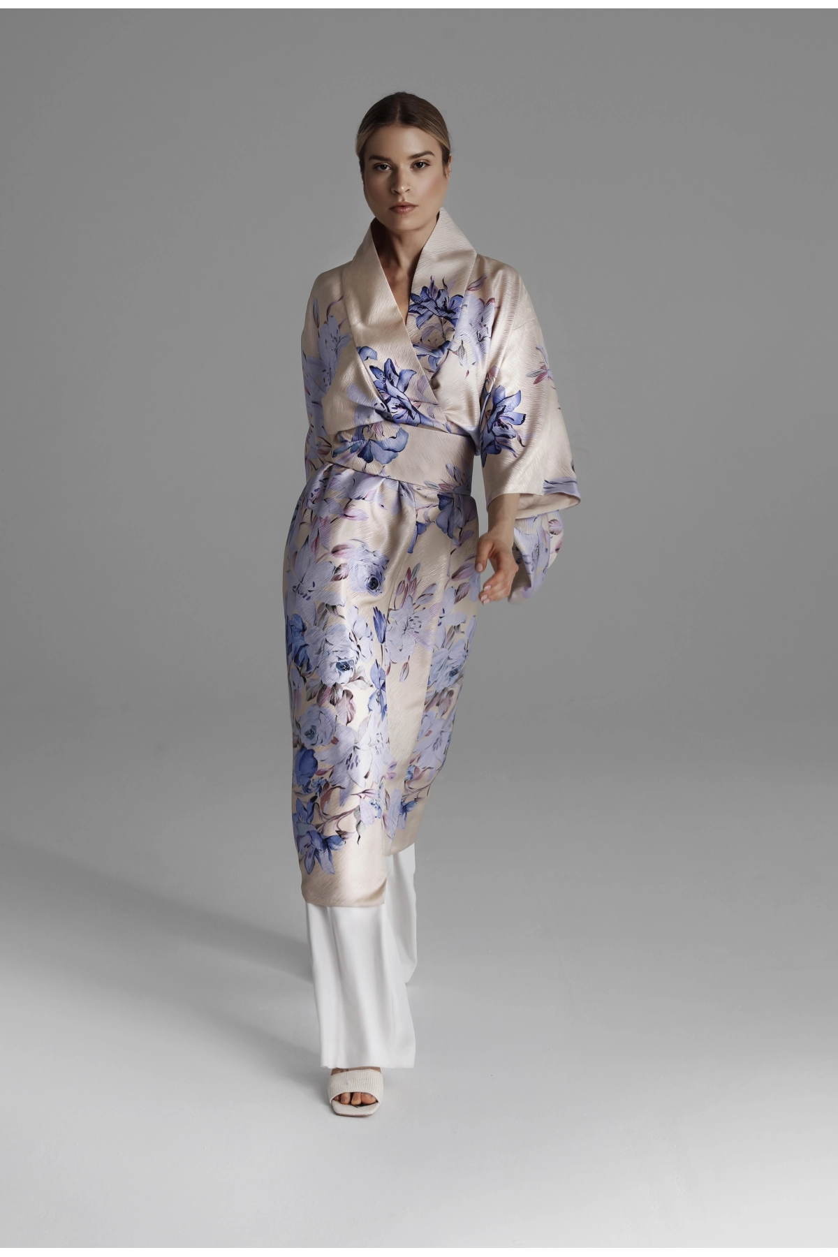 A picture of a model walking ahead in a kimono with a belt tied at the waist.