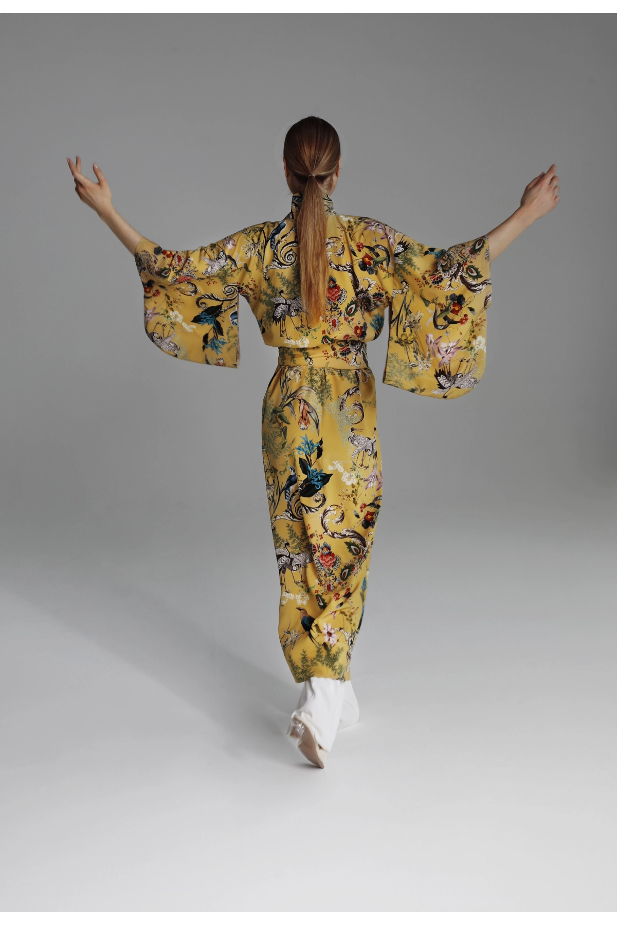 Model presenting the back of the kimono with the cut of the sleeves on display.