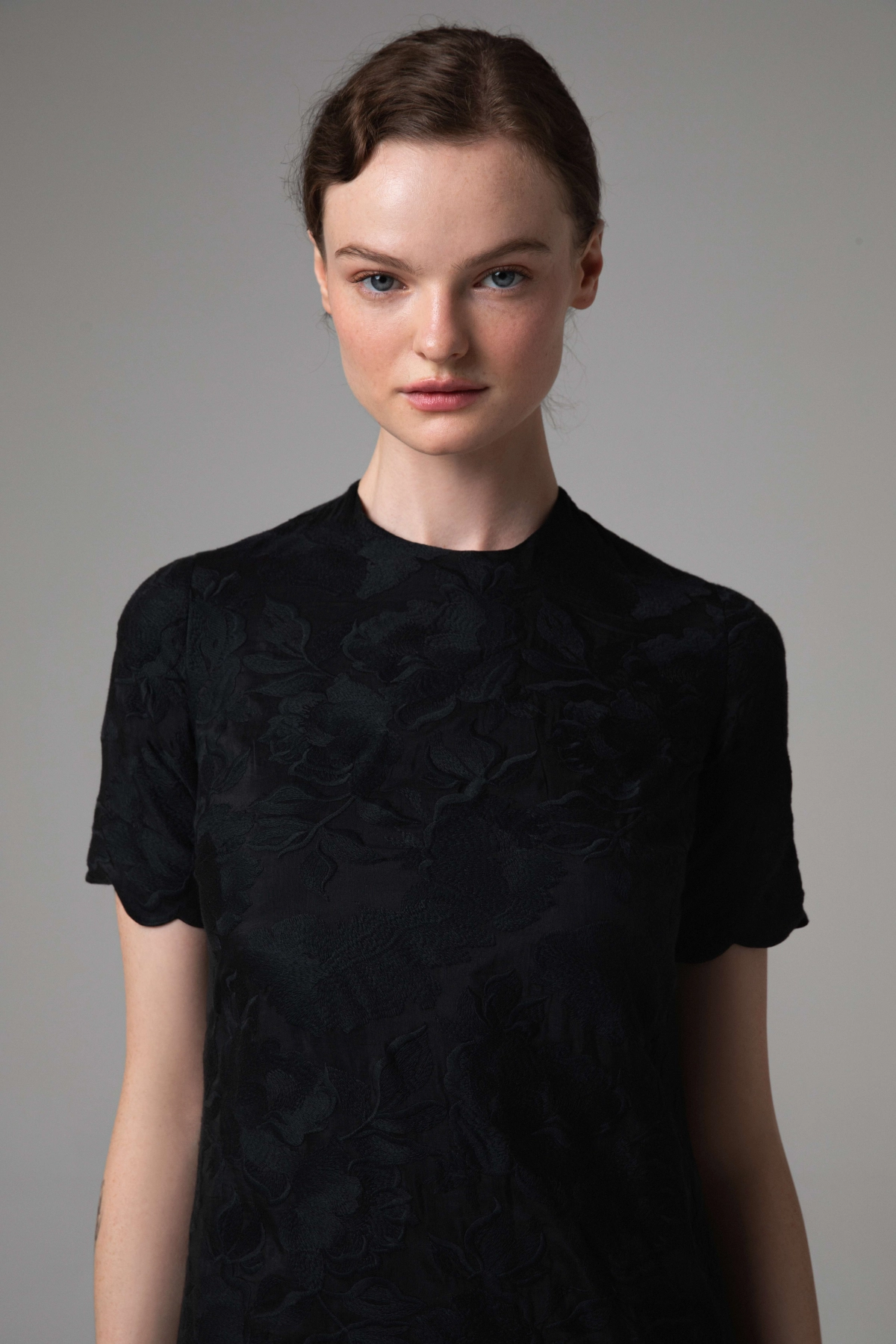 Black dress with floral embroidery, close-up of neckline and sleeve details