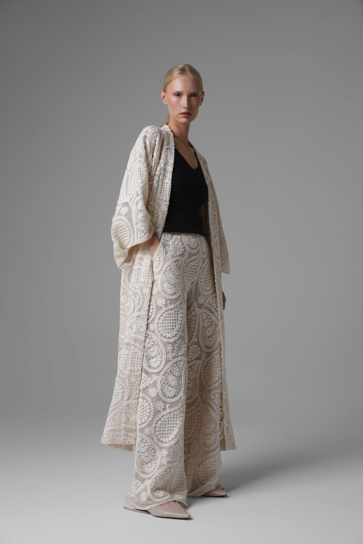 Model presenting long paisley artisan kimono, full side view, airy openwork design