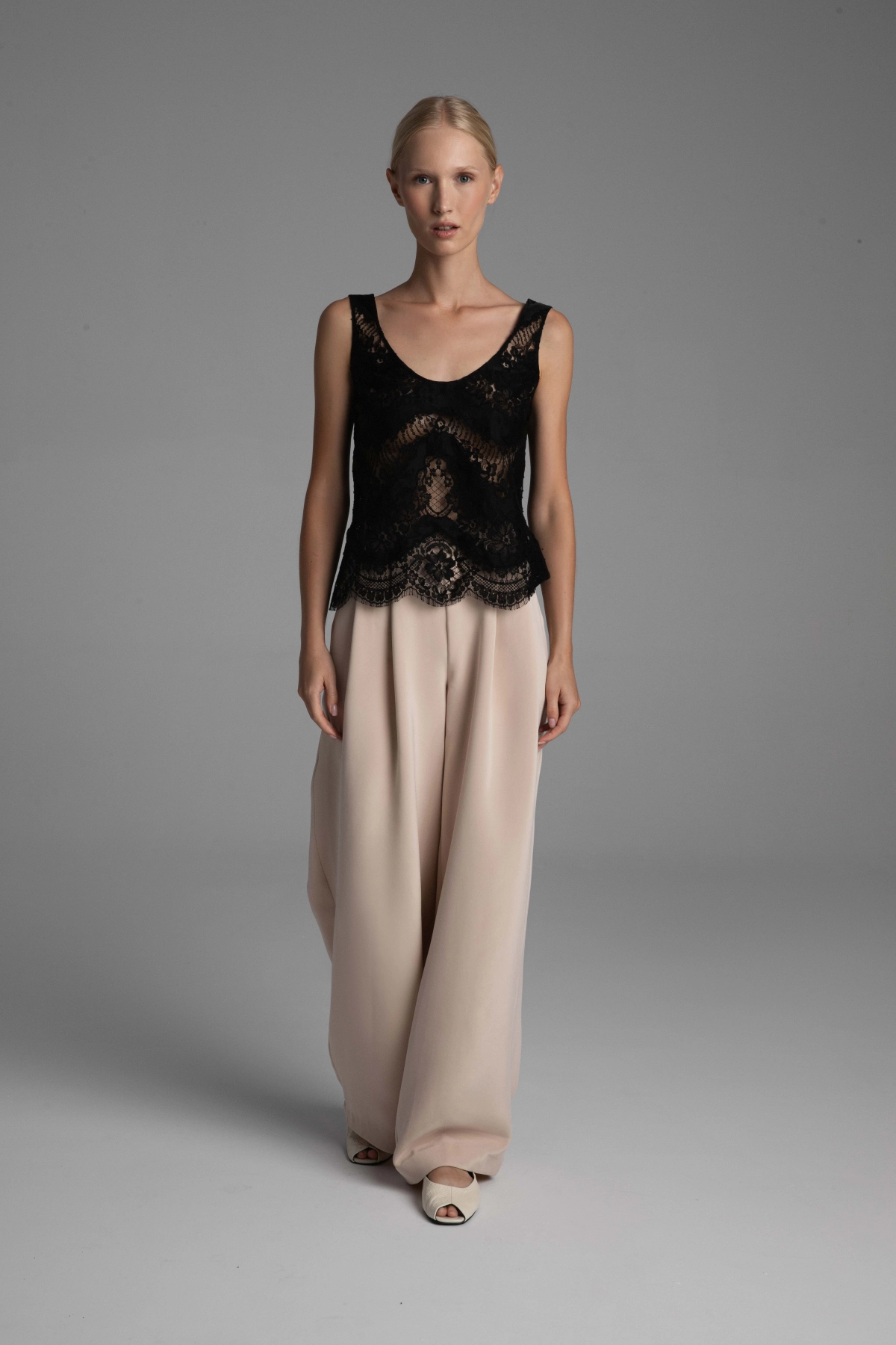 Model presenting a blouse and light silk trousers by Monika Adamska.