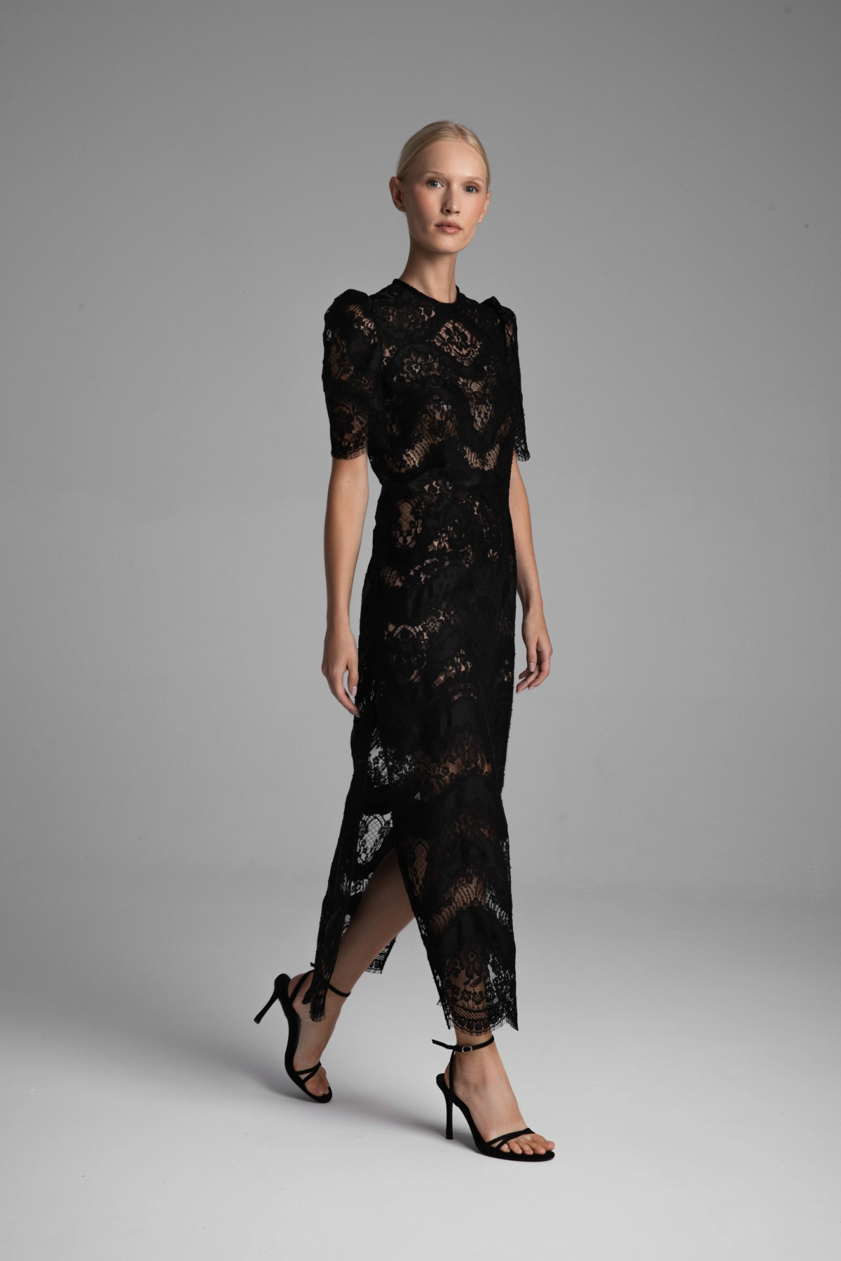 A model presenting the entire front of a black dress.