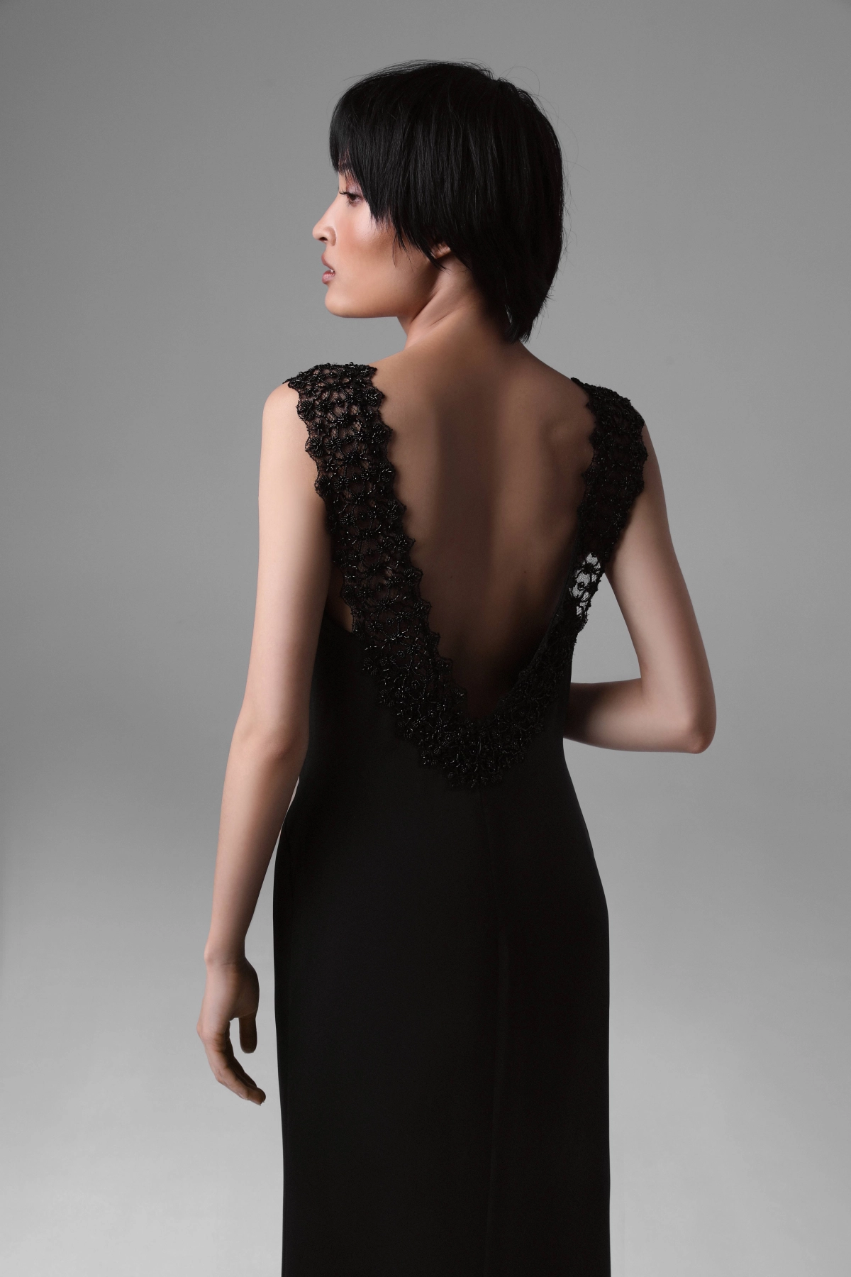 Back view of Monika Adamska black silk evening dress, highlighting deep V beaded lace back and elegant silhouette