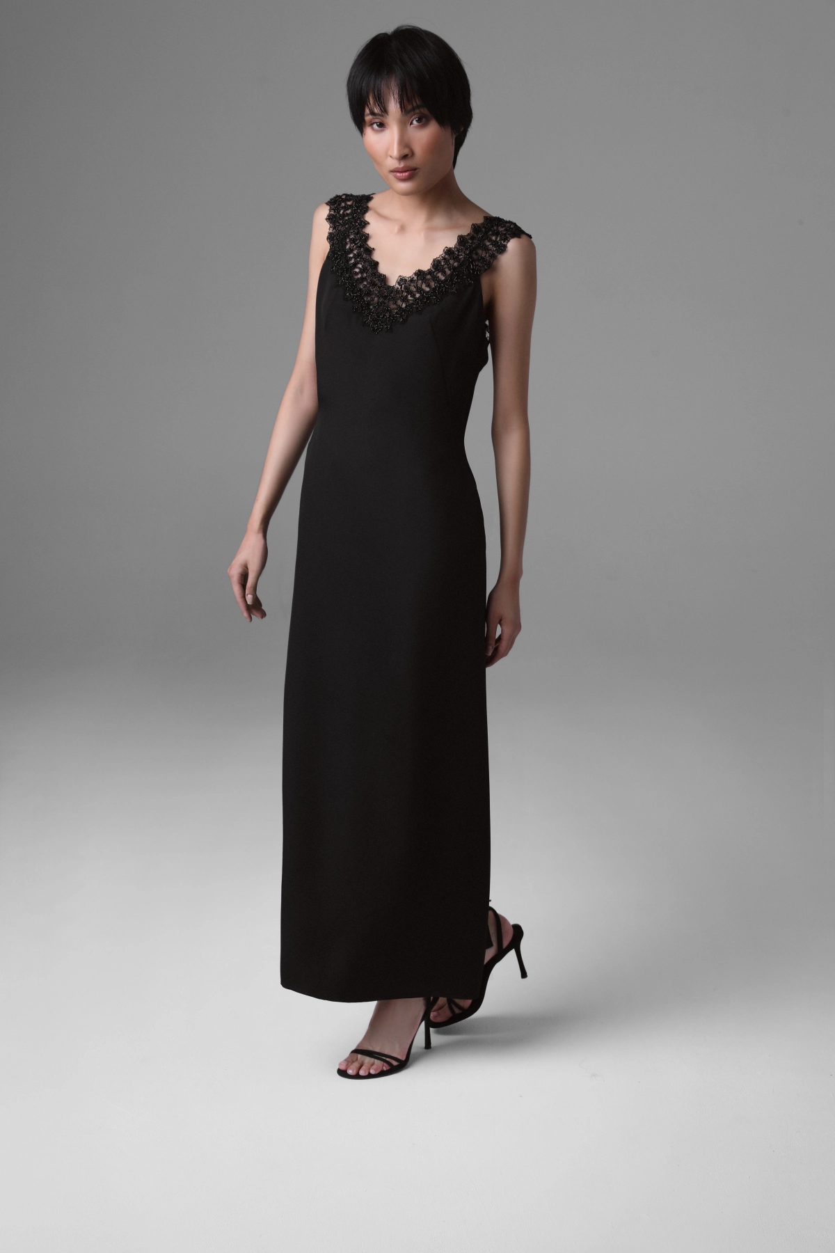 Full-length view of Monika Adamska black silk evening dress with beaded French lace, shown with strappy black heels