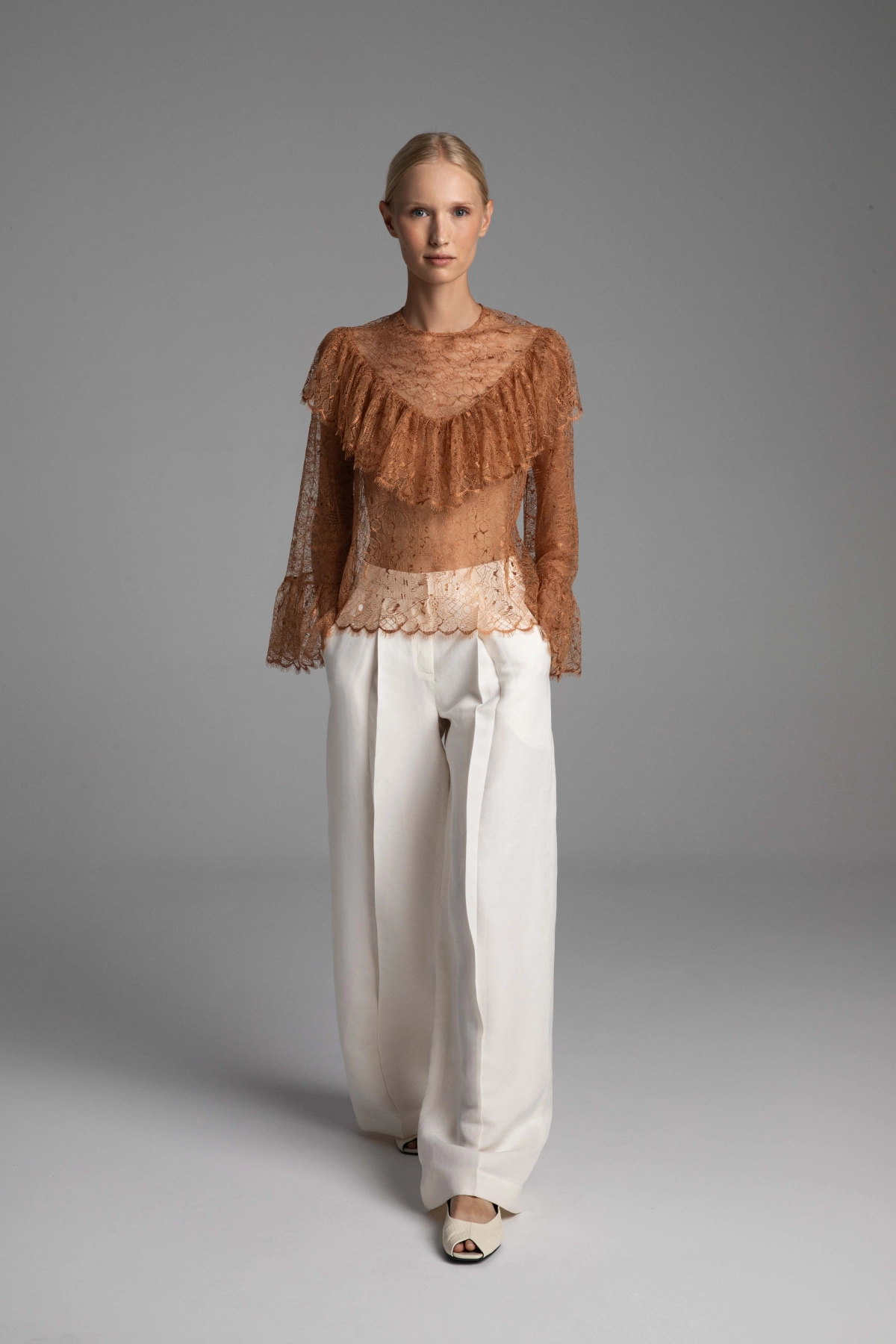 Monika Adamska copper French lace blouse styled with white trousers, highlighting how the color harmonizes with the skin tone.