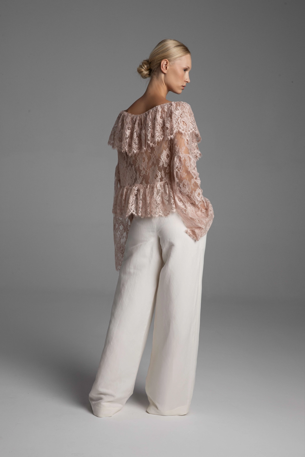 Back view of Monika Adamska off-white trousers with a pressed crease, showcasing the architectural form.