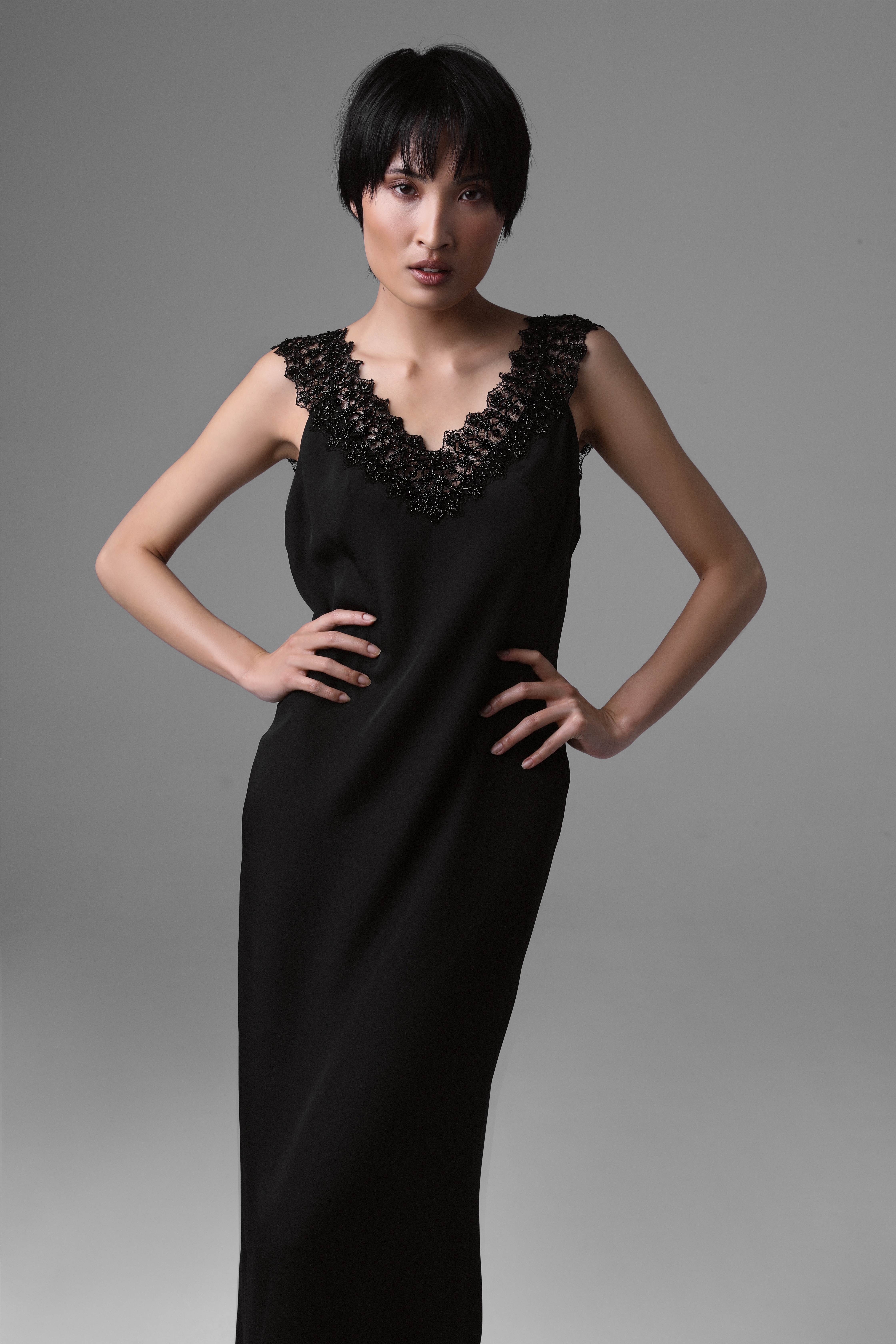 Video showcasing Monika Adamska black silk evening dress with beaded French lace: model walks across the frame, pauses center stage, and turns to display the dress from every angle